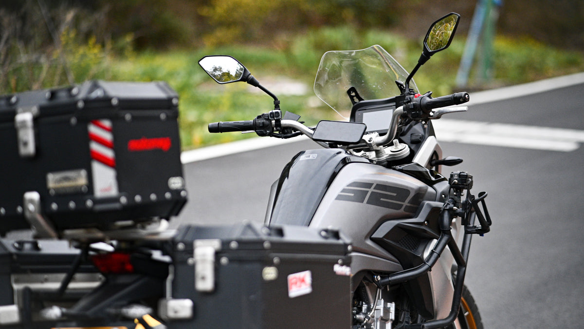 Moto adventure con valigie in alluminio e smartphone su porta cellulare da manubrio, pronta per un viaggio