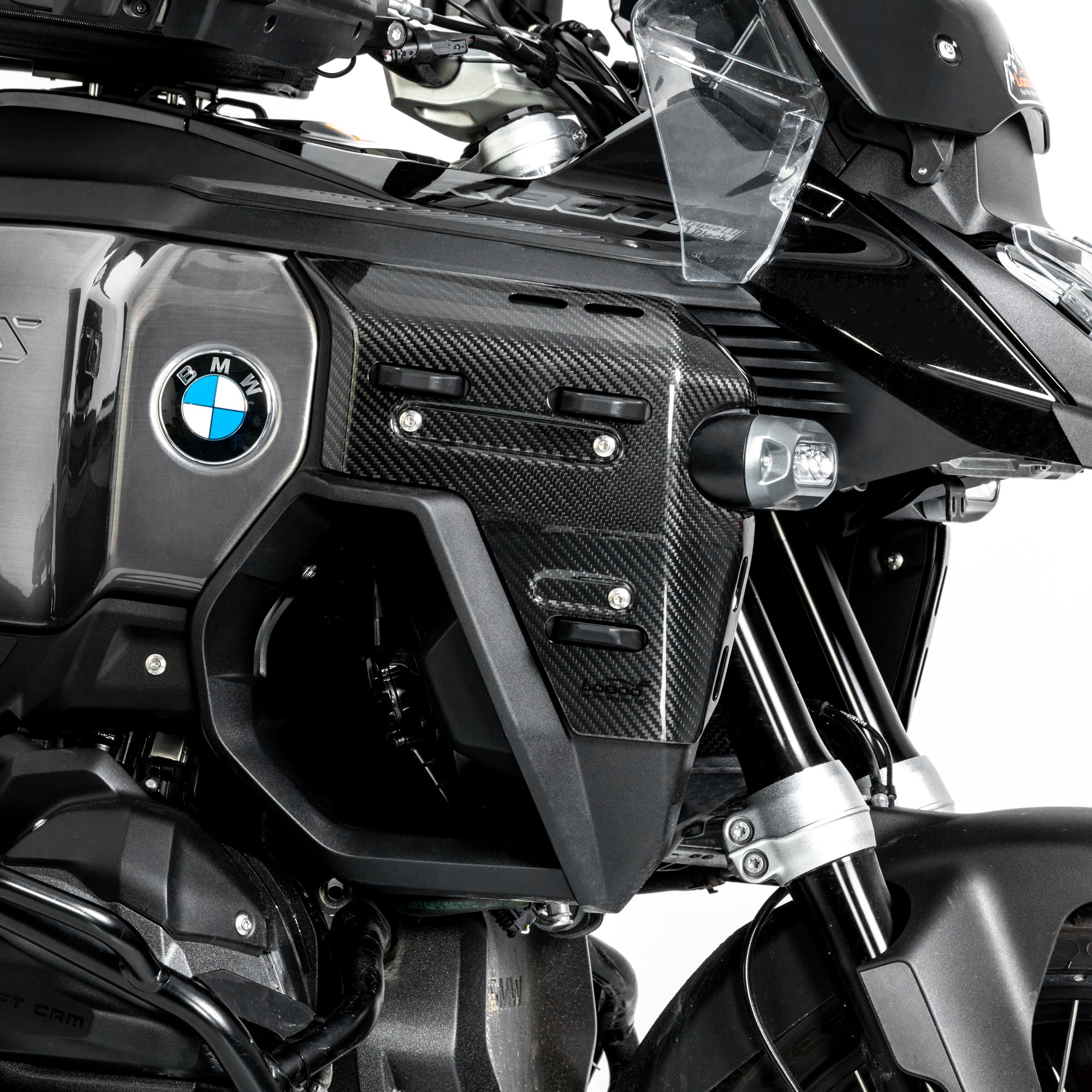 Dettaglio ravvicinato della cover in carbonio montata accanto al logo BMW