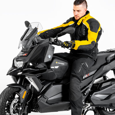 Motociclista in sella allo scooter con la borsa tunnel montata fra le gambe