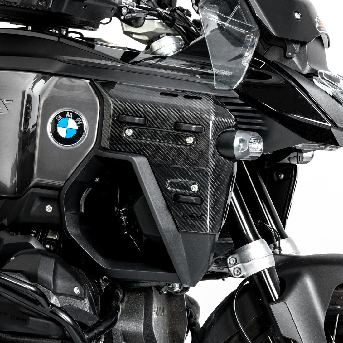 Dettaglio ravvicinato della cover in carbonio montata accanto al logo BMW