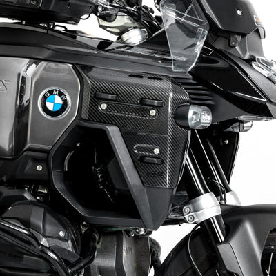 Dettaglio ravvicinato della cover in carbonio montata accanto al logo BMW
